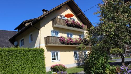 a yellow house with a balcony with flowers at Ferienhaus Ball - Kometterhof in Hermagor