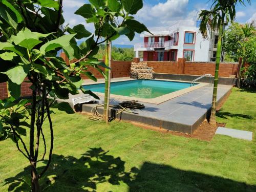a swimming pool in the yard of a house at Karjat - 3 BHK Private Bungalow with Private Pool & Garden in Karjat