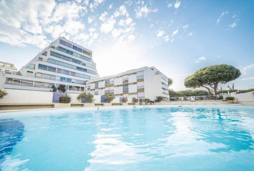 une grande piscine devant un immeuble dans l'établissement Appartement à quelques pas de la mer WIFI CLIM PARKING, à La Grande Motte