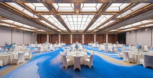 a large banquet hall with white tables and chairs at Crowne Plaza Suzhou by IHG in Suzhou