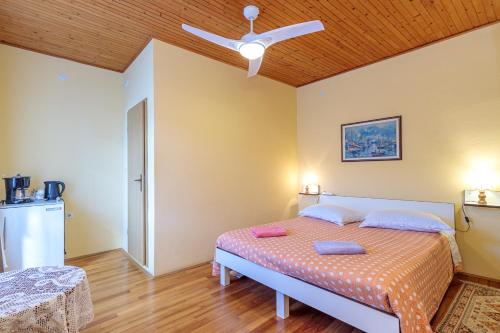 een slaapkamer met een bed en een plafondventilator bij Rooms Nela in Hum