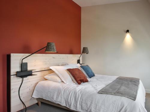 a bedroom with a white bed with two lamps on it at BERCAIL in Wambrechies