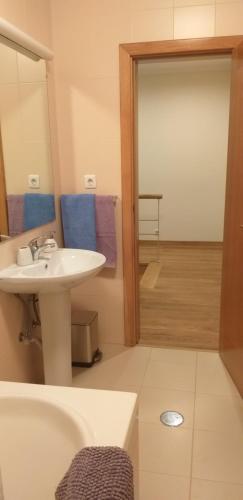 ein Badezimmer mit Waschbecken, Badewanne und Spiegel in der Unterkunft Casa do Sol in Arouca