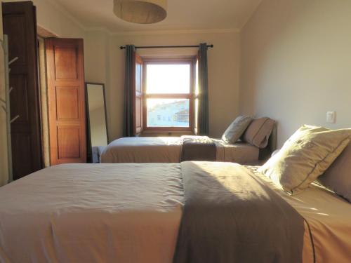ein Schlafzimmer mit zwei Betten und einem Fenster in der Unterkunft Casa do Sol in Arouca