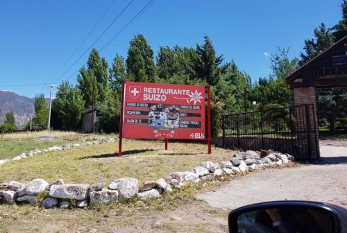 a sign on the side of a road at Cabañas swissminiatur in Cacheuta