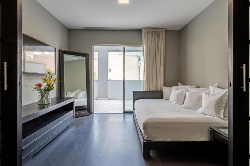 Suites Giorgio في مدينة ميكسيكو: غرفة نوم مع سرير وخزانة ومرآة