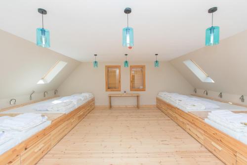 an attic room with a row of beds at Illaberek Vendégház in Sukoró