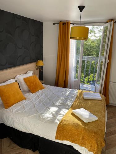 Un dormitorio con una cama con almohadas amarillas y una ventana en Ménil Bon Temps, en París