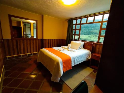 a bedroom with a bed and a window at Hotel COTURPA in Papallacta