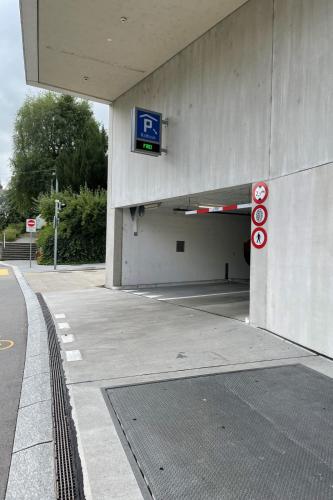 an entrance to a parking lot with a parking sign at Modern apartment in a charming old town setting in Altstätten