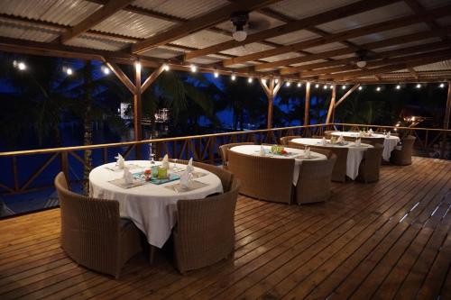 a restaurant with white tables and chairs on a deck at Azul Over-the-Water Resort in Bocas Town