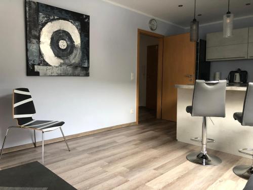 a living room with two chairs and a kitchen at Ferienwohnungen Margot in Iserlohn
