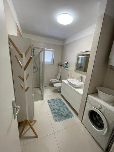 uma casa de banho com uma máquina de lavar roupa e um lavatório em Petra Apartment em Split