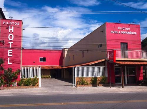un edificio rojo al lado de una calle en Pousada Pilotos en Itapipoca