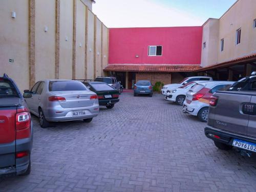 a parking lot with cars parked in front of a building at Pousada Pilotos in Itapipoca