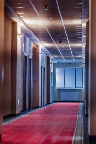 an empty hallway with a red carpet in a building at Boutique Hotel's Bytom in Bytom