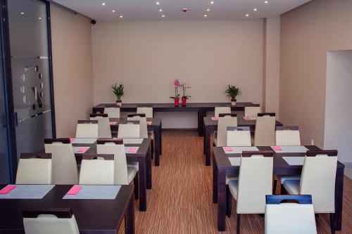 an empty room with tables and white chairs at Boutique Hotel's Bytom in Bytom