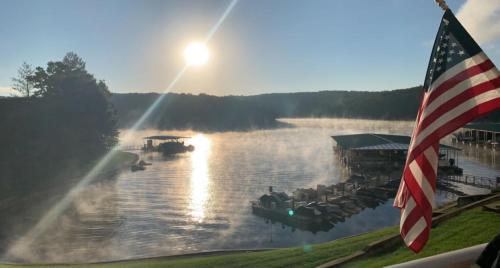 a boat on a river with an american flag at Family Fun Lakefront Condo at Parkview Bay in Osage Beach