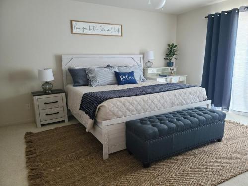 a bedroom with a bed and a blue ottoman at Family Fun Lakefront Condo at Parkview Bay in Osage Beach