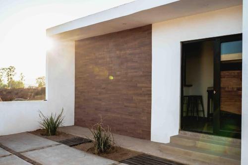 a house with a brick wall and a window at Collins Village Hotel Boutique in El Porvenir