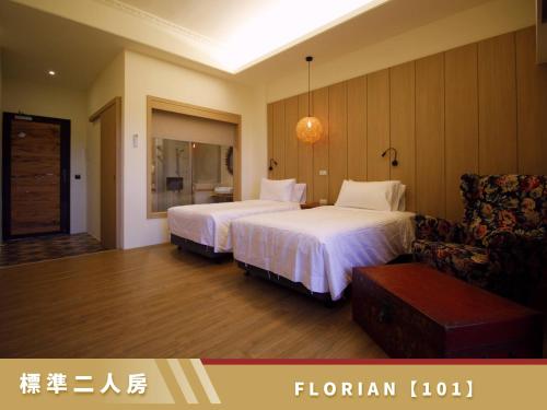 a hotel room with two beds and a chair at 豐 FONG PENSiON - 無合作 ᴀɢᴏᴅᴀ 平台 in Taitung City