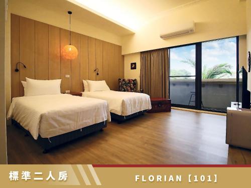 a hotel room with two beds and a large window at 豐 FONG PENSiON - 無合作 ᴀɢᴏᴅᴀ 平台 in Taitung City