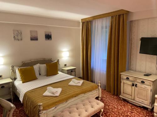 a hotel room with a bed with yellow pillows at Grand Hotel&Restaurant in Bačka Palanka