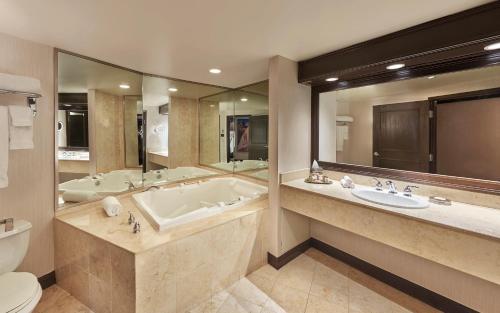 La salle de bains est pourvue d'une baignoire, de deux lavabos et de toilettes. dans l'établissement Treasure Island - TI Las Vegas Hotel & Casino, a Radisson Hotel, à Las Vegas