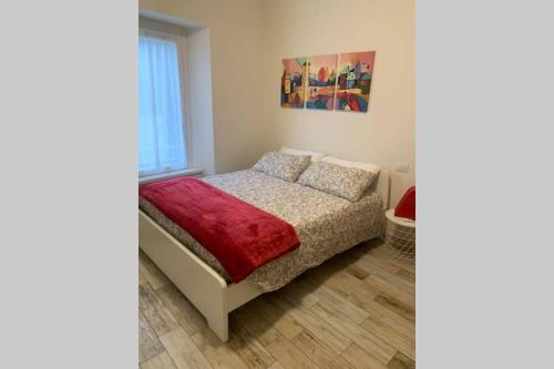 1 dormitorio con 1 cama con manta roja en La Cascinetta - BGY Airport, en Grassobbio