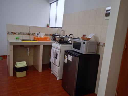 a kitchen with a microwave on top of a refrigerator at 201 Departamento exclusivo en Chorrillos in Lima