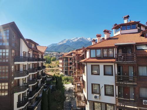 a group of buildings with mountains in the background at Studio in Murphys Lodge in Bansko