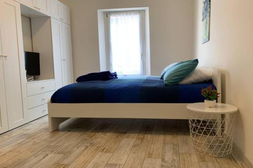 um quarto com uma cama com lençóis azuis e uma janela em BGY Airport - La Cascinetta em Grassobbio