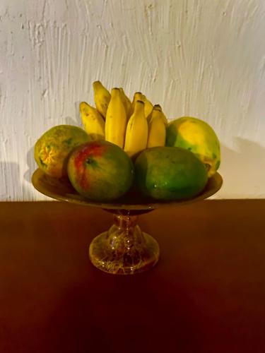 a bowl of fruit on a plate with bananas and pears at Ipanema Club Hostel in Rio de Janeiro