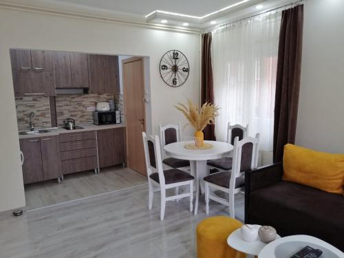 a living room with a white table and a kitchen at Apartman Ži-Zo in Vršac