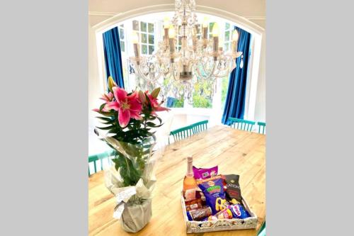 a vase with a flower and a box of candy at Cleveland House - Perfect for Beaches and Town. in Bournemouth
