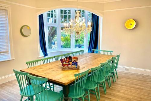 a dining room with a wooden table and green chairs at Cleveland House - Perfect for Beaches and Town. in Bournemouth