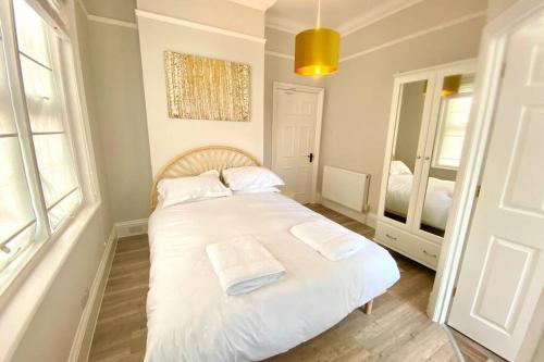 a bedroom with a white bed with two towels on it at Cleveland House - Perfect for Beaches and Town. in Bournemouth