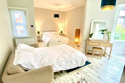 a bedroom with a white bed and a mirror at Cleveland House - Perfect for Beaches and Town. in Bournemouth
