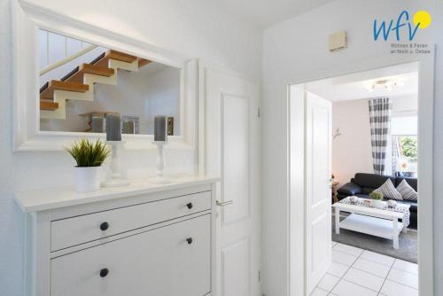 a living room with a staircase and a white dresser at Ferienhaus Seepferdchen in Borkum
