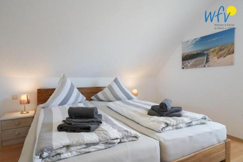 a bedroom with two beds with towels on them at Ferienhaus Seepferdchen in Borkum