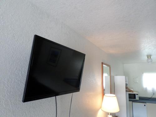telewizor z płaskim ekranem wiszący na ścianie w obiekcie Sandman Motel w mieście Libby