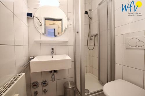 a small bathroom with a sink and a shower at Haus Solaris - Ferienwohnung D'runner un D'rover in Wangerooge