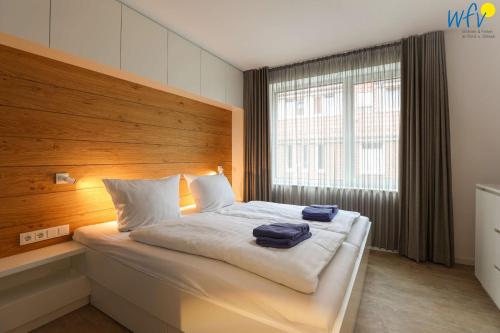 a bedroom with a bed with two towels on it at Haus Talita - Wohnung ECHO in Juist