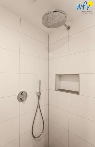 a white bathroom with a shower with a shower head at Haus Talita - Wohnung ECHO in Juist