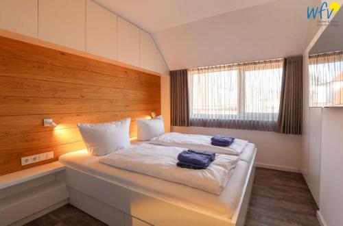 a bedroom with a bed with two bags on it at Haus Talita - Wohnung PAPA in Juist