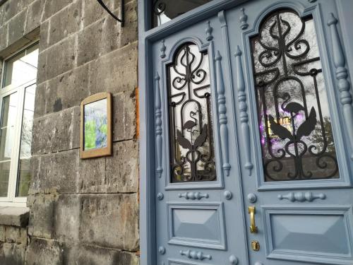 een blauwe deur op een gebouw met glas in lood bij Konjelazia - Tourism & Design in Gjoemri