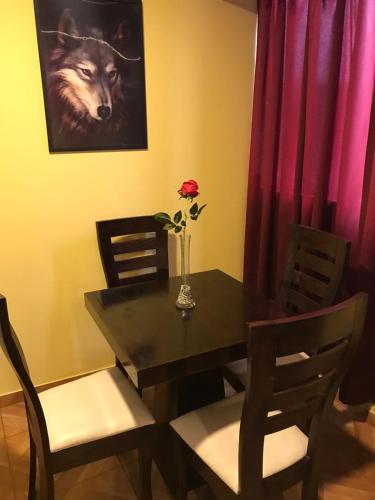 a dining room table with a wolf picture and a vase with a rose at 300 Departamento Centrico distrito de chorrillos in Lima