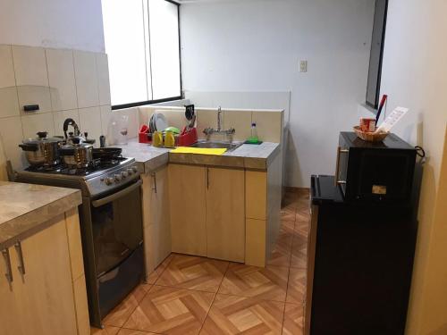 a kitchen with a stove and a sink at 300 Departamento Centrico distrito de chorrillos in Lima