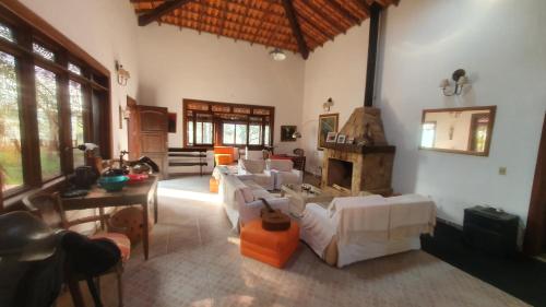 パティ・ド・アルフェレスにあるPousada das Casuarinasのリビングルーム(白いソファ、暖炉付)