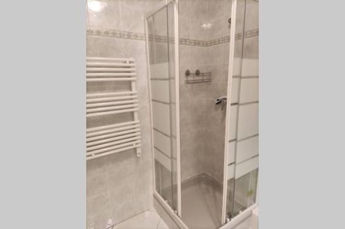 une salle de bain avec une douche avec une porte vitrée dans l'établissement Havre de paix en plein centre ville, 4 couchages, à Menton